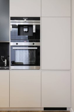 Mutfak mobilyalarının içinde fırın ve kahve makinesi var.