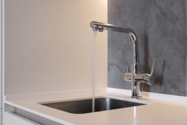 Mutfaktaki musluktan su dökülüyor.