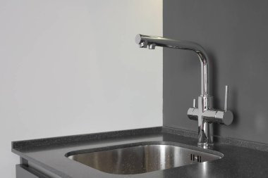 Mutfakta lavabosu olan bir musluk.