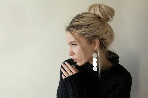 パステルの背景に暖かい黒いセーターとファッションジュエリーを身に着けている美しい若い女の子 トレンドミニマルエステティックスタイル — ストック写真
