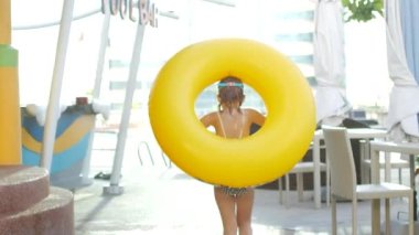 Kız ve sarı şişme yüzük su parkında..