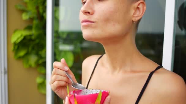 Skallig Kvinna Äter Drakfrukt Balkongen — Stockvideo