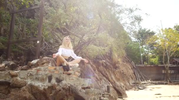 Ung Blondin Mediterar Medan Han Sitter Stor Sten Tropisk Strand — Stockvideo