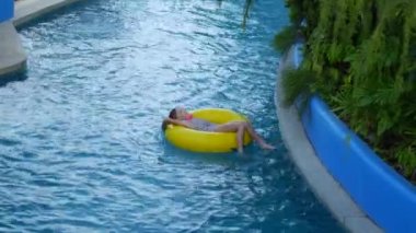 Girl and yellow inflatable ring in the water park.