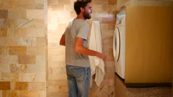 男が洗濯機に物を投げ込み電源を入れる — ストック動画