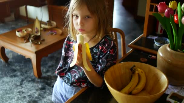 Κορίτσι Τρώει Μια Μπανάνα Στην Κουζίνα Σνακ Μεταξύ Online Μαθημάτων — Αρχείο Βίντεο