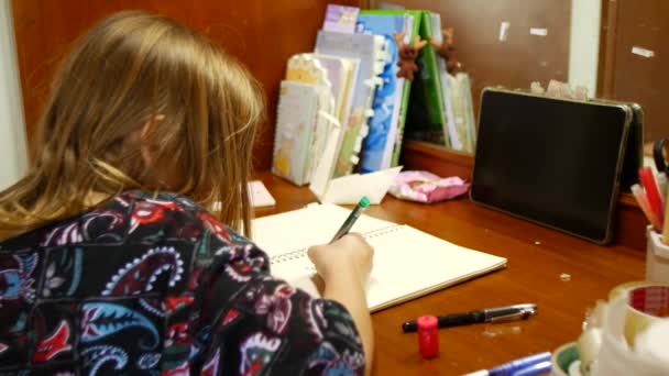Chica Hace Los Deberes Estudiante Escribe Cuaderno Mientras Está Sentada — Vídeo de stock