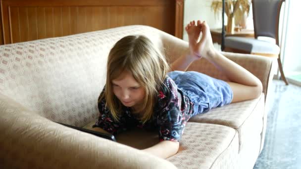 这个女孩躺在沙发上玩网络游戏 — 图库视频影像