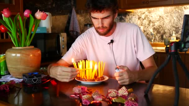 一个36岁的男子在蛋糕上点蜡烛 许愿并试图吹灭蜡烛 但它们不会吹灭 男人笑了 — 图库视频影像
