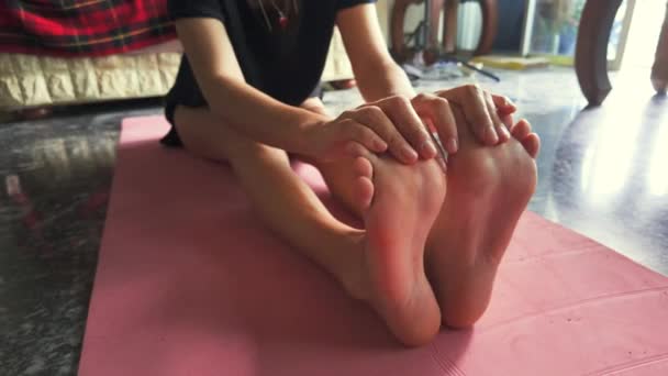 一个女孩在瑜伽垫上伸着脚趾 展示伸展运动或瑜伽运动 这段视频适合于健身 健康和生活方式项目 抓住了灵活性的本质 — 图库视频影像