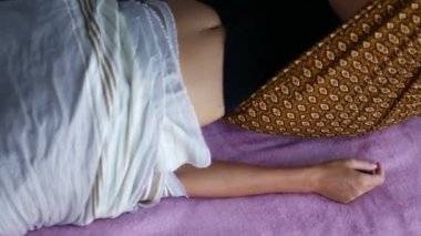 Yumuşak çarşaflara sarılmış bir kadın rahatlatıcı bir kaporta seansı alırken bir an için rahatlayın. Nazik hareketler ve uzman bakımıyla, bu terapi deneyimi huzur verir.