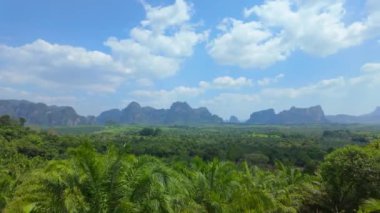 Kendinizi Tayland 'ın Krabi eyaletinin nefes kesici güzelliğine daldırın. Yeşillik, görkemli dağlar ve doğal ihtişamın görkemli bir manzarasını oluşturan geniş gökyüzü.
