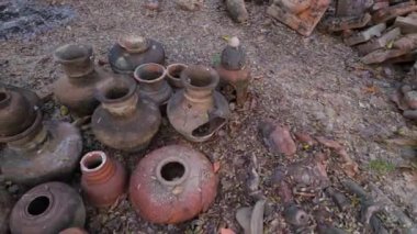 Sayısız yıpranmış kil çömlek bir araya toplanmış, kırsal bir cazibe sergiliyor.