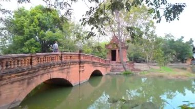 Sakin bir nehrin üzerinde kavis çizen eski tuğla köprü, tarihi cazibeyle resim gibi bir sahne yaratıyor.