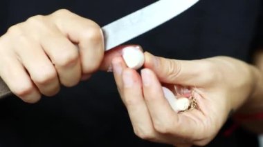 Kadın elleri sarımsak ve soğanı nazikçe soyarken, yemek ve yemek hazırlığının özünü yakına çekerken karmaşık detaylar. Aşçılık dersleri, yemek gösterileri ve yemek için mükemmel.