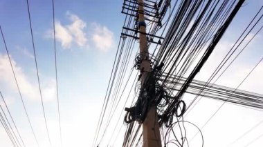 Elektrik kablolarının silueti Asya gökyüzünün zemininde çapraz çaprazlama dolaşarak, hareketli şehirlerin modern altyapı ve enerji ağını sembolize ediyor. Kentsel keşif videoları için mükemmel