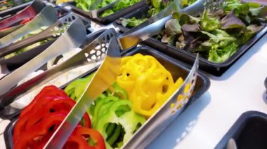 Kendi salata istasyonunu kurmak için salata hazırlama, kişiselleştirilebilir salata deneyimi için çeşitli taze malzemeler sunma
