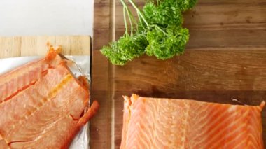 Taze maydanozla süslenmiş füme somonun nefis tadı, ahşap bir kesme tahtasına güzelce sunulmuş, gurme mutfak işçiliğinin özünü yakalıyor.