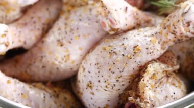 Taze terbiye edilmiş tavuk budu cızırtısı, aromatik baharatlarla bol baharatlı, ızgaraya hazır, yemek mükemmelliğinin cazibesiyle cezbedici izleyiciler..