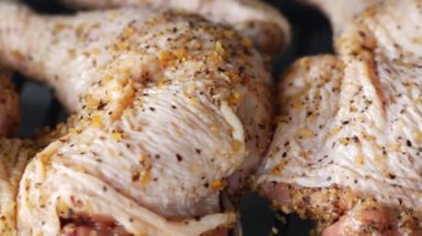 Taze terbiye edilmiş tavuk budu cızırtısı, aromatik baharatlarla bol baharatlı, ızgaraya hazır, yemek mükemmelliğinin cazibesiyle cezbedici izleyiciler..