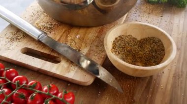 Aşçı ustalığı tavuk butlarını ustalıkla terbiye eder, aromatik baharatlarla sergiler, taze kiraz domatesleri, otlar ve baharatlar masayı süslerken,