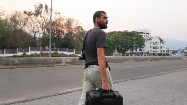 人走在路上 提着手提箱 象征着步行旅行的决心和独立 — 图库视频影像