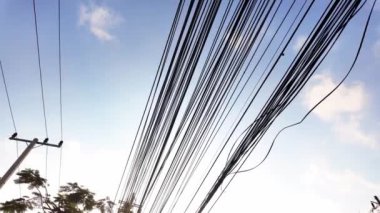Elektrik kablolarının silueti Asya gökyüzünün zemininde çapraz çaprazlama dolaşarak, hareketli şehirlerin modern altyapı ve enerji ağını sembolize ediyor. Kentsel keşif videoları için mükemmel