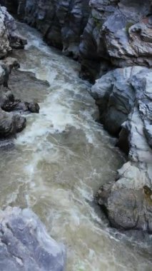 Bir video, kanyonlardan akan nehirleri ve kayalarla çevrili su kütlelerini gösteriyor. Sahneler doğada huzur ve sükunet getirir.