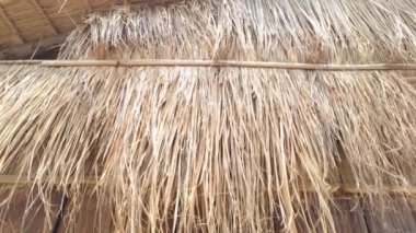 Kuru otlarla kaplı, sağlam ahşap bir duvarla tamamlanmış bir çatının kırsal güzelliği. Bu sahne doğal bir cazibe yayıyor, basitlik ve kırsal estetiği çağrıştıran projeler için mükemmel..