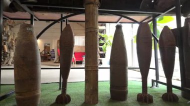 Laos 'taki bir müzede sergilenen bomba parçaları ve patlamamış mühimmat da dahil olmak üzere savaş kalıntıları. Bu video çatışmanın yıkıcı etkisini vurguluyor ve tarihin ve tarihin hatırlatıcısı olarak hizmet veriyor.