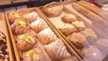 Çörekler ve kruvasanlar da dahil olmak üzere çeşitli yeni pişmiş yiyecekler bir fırın tezgahına düzgünce yerleştirilmiştir. Yemek pişirme, yemek pişirme ve aşçılık sanatlarıyla ilgili konular için mükemmel..