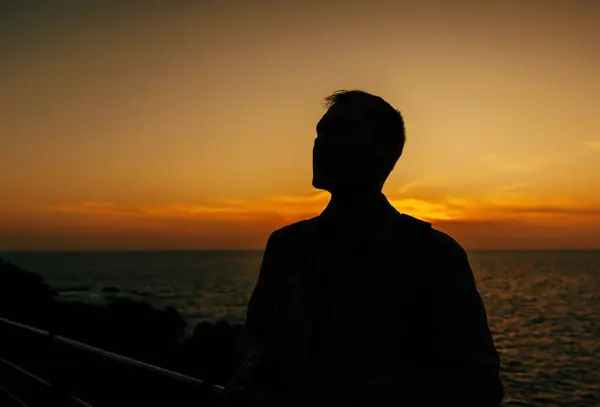 人生を考えている男のシルエットは スペインのテネリフェ島の明るい日没の空に対して概説されています ロイヤリティフリーのストック写真