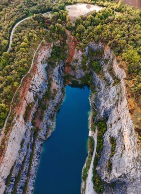 Açık mavi gölü ve etrafını çevreleyen ön kısımları olan derin kayalık kanyon manzarası.
