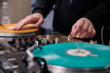 Hip hop DJ 'i sehpaya plak çizer. Ses kayıt stüdyosunda pikaplara vinil çizen bir disk jokey.