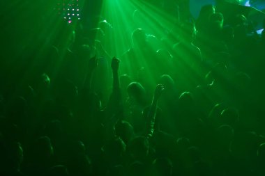Konser kalabalığının silueti eğleniyor. Bir grup genç gece kulübünde parti veriyor.