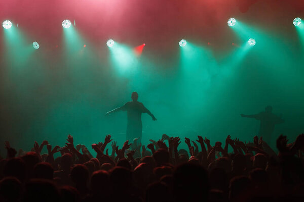 Рэп-певец выступает на концерте в мюзик-холле. Силуэт рэпера, поющего на сцене в ночном клубе