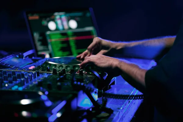 Techno dj mixing musical set on party in night club. Disc jockey plays on rap concert in nightclub