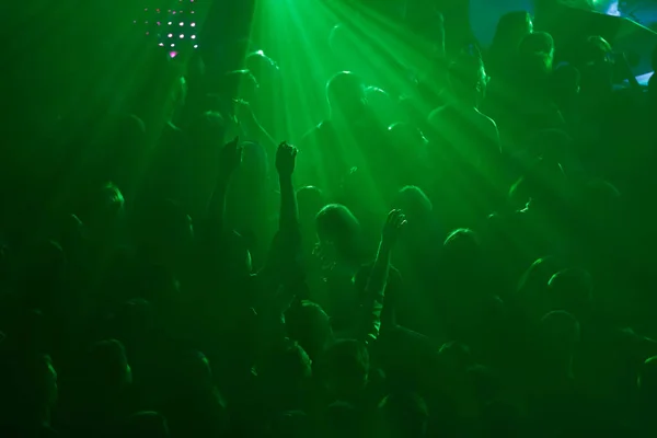 stock image Silhoutte of concert crowd having fun. Group of young people partying on rave in night club