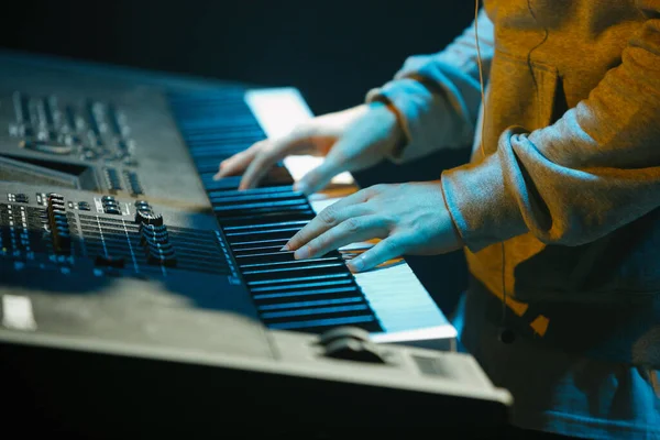 Musician plays music on electronic piano device on stage