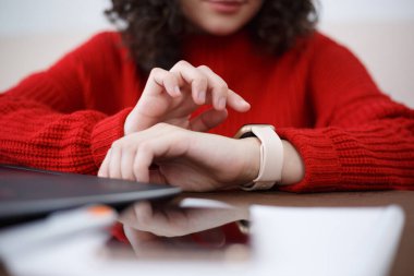 Student girl using smartwatch gadget in close up. Young female person browsing notifications and messages on smart wrist watches