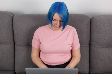Female programmer typing code on laptop at home. Freelancer woman coding on modern notebook computer with a smile