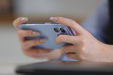 Gamer girl plays onilne mobile games on smart phone. Close up photo of young female person playing videogames on gadget