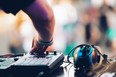 DJ plays music on summer festival. Disc jockey using midi controller device on concert