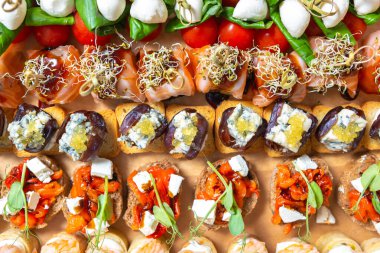 Flat lay photo of group of gourmet snacks delivered for food catering service on a wine party. Overhead image of delicious canape assortment