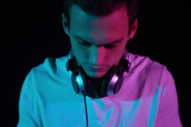 Portrait of club DJ mixing music on party. Young handsome white man plays deejay set in night club