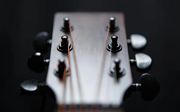 Guitar head and tuning pegs in closeup. Professional acoustic guitar in close up