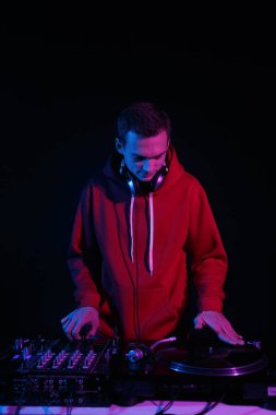 Hip hop DJ scratches records on turntables. Disc jockey mixing vinyl set on party in night club