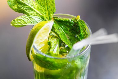Limonlu ve nane yapraklı mojito kokteyli. Bardakta buzlu taze yeşil alkollü içecek. 