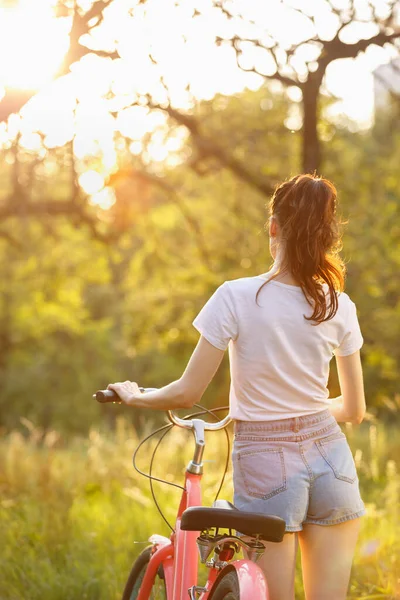 Seksikäs Nuori Nainen Shortseissa Kävelemässä Polkupyörän Kanssa Auringonlaskun Aikaan Kaunis — kuvapankkivalokuva
