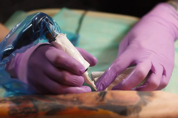 電気機械の針で人間の皮膚に新しい入れ墨を作る入れ墨 仕事中の現代的な電動タトゥー銃 — ストック写真